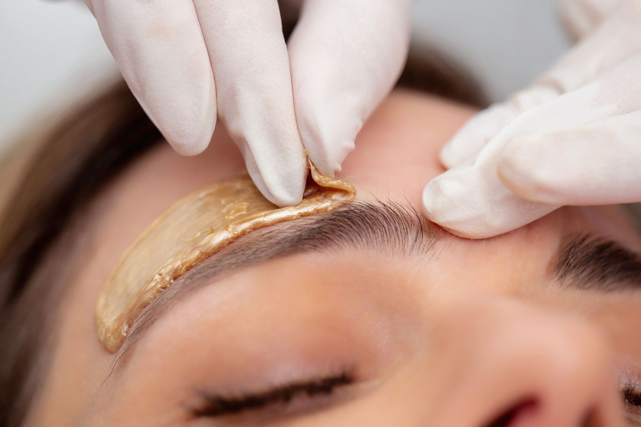Close-up of eyebrow waxing procedure