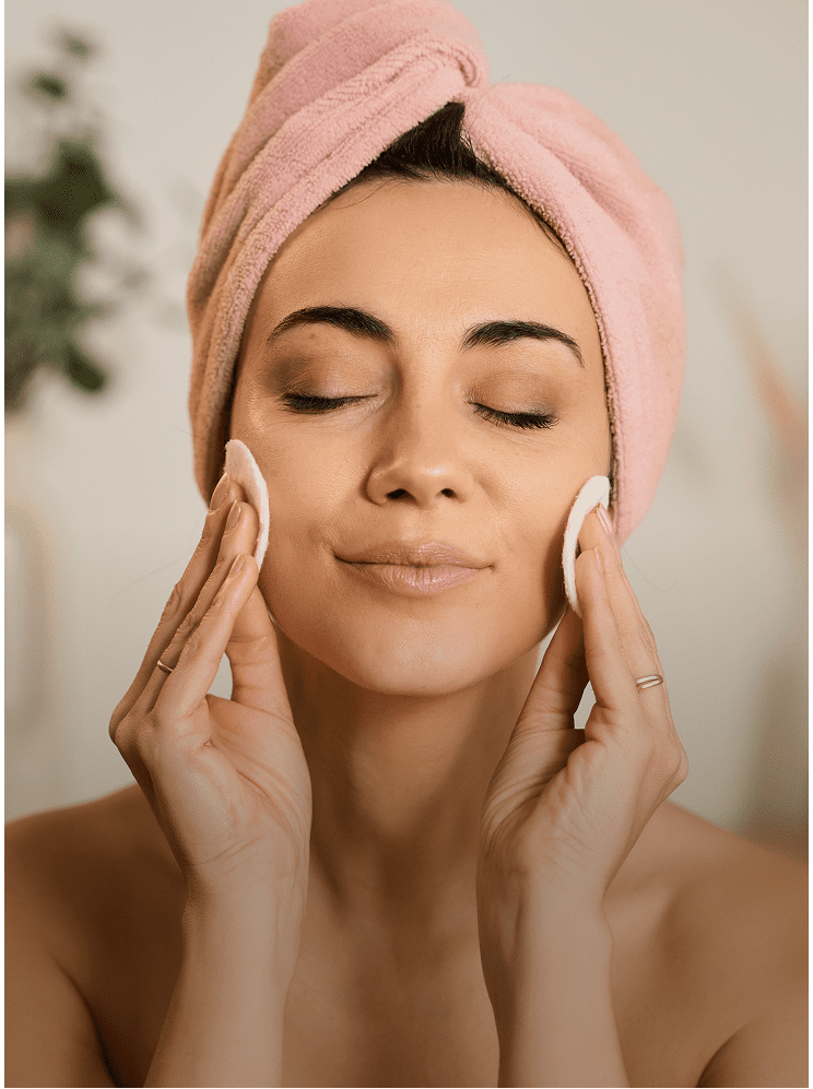Woman cleansing face with cotton pads